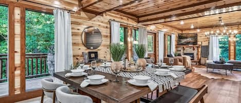A wooden interior with a dining table set for six, surrounded by chairs.