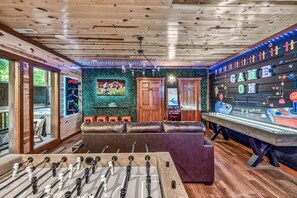 Ein Zimmer mit einem Kicker, einer Couch und einem Spiel auf dem Kicker.