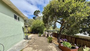 A residential backyard with a gravel path, a pergola, and potted plants. - Monterey Getaway - Fabulous 3-bedroom house in Monterey (Monterey)