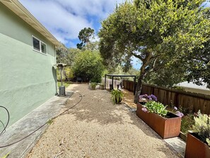 A residential backyard with a gravel path, a pergola, and potted plants. - Monterey Getaway - Fabulous 3-bedroom house in Monterey (Monterey)
