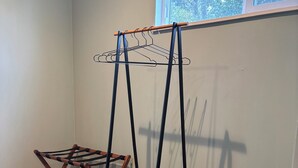 A room with a wooden floor, a window with a view of trees, and a metal drying rack. - Monterey Getaway - Fabulous 3-bedroom house in Monterey (Monterey)