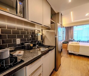 Eine kleine Küche mit Herd, Spüle und einem Kühlschrank von Electrolux.