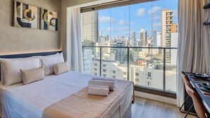 Una camera d'albergo con un letto grande, una scrivania e vista sulla città.