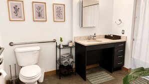 A modern bathroom with a toilet, sink, and towel rack. - Modern Downtown Detroit Loft with Skyline views (Detroit)