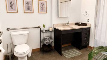 A modern bathroom with a toilet, sink, and towel rack.