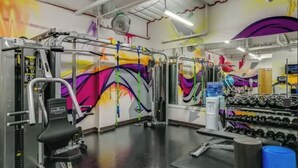 A gym with various exercise equipment, including a weight bench, dumbbells, and a pull-up bar. - Modern Downtown Detroit Loft with Skyline views (Detroit)