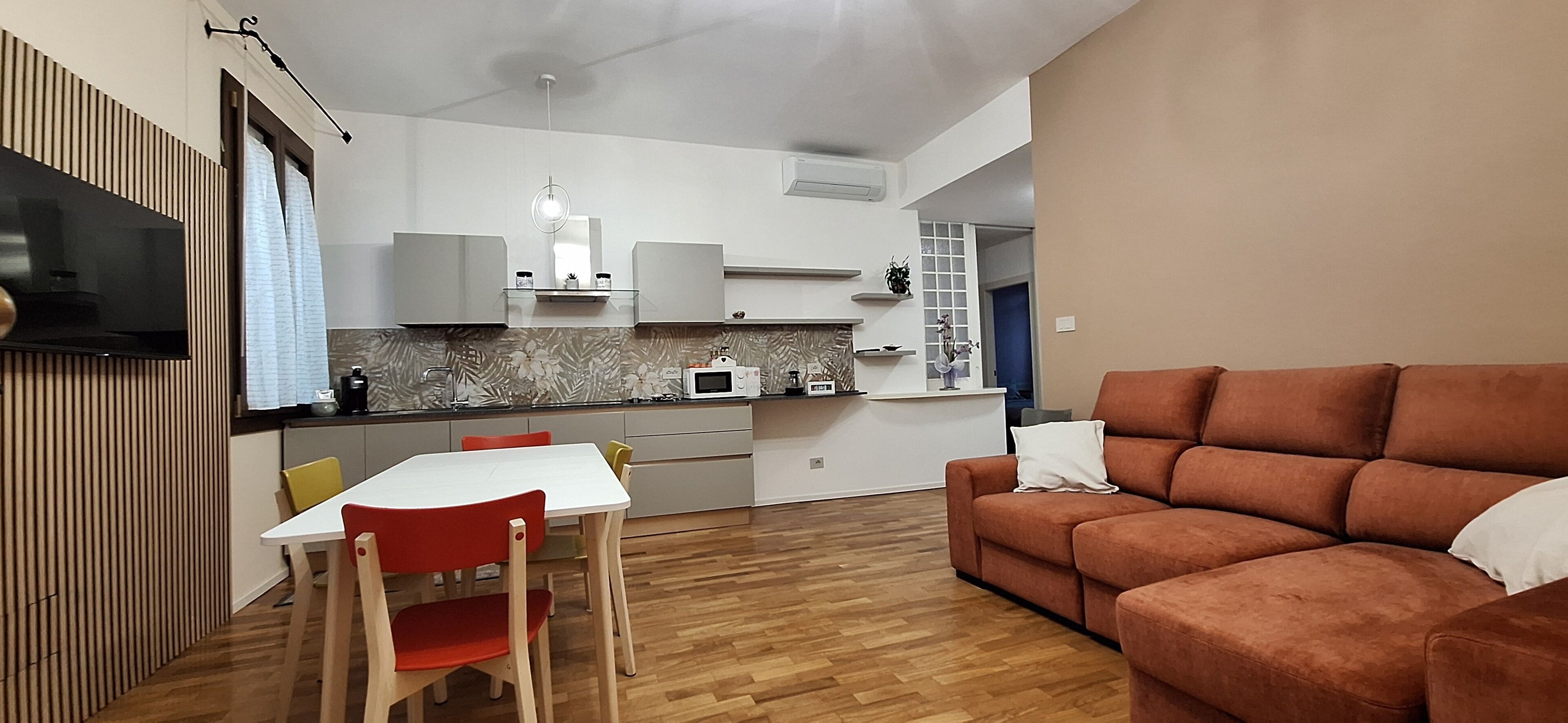 Un espace de vie compact comprenant un coin cuisine, un coin repas avec une table et des chaises, et un canapé.