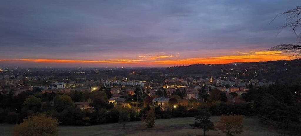 Une vue sur une ville au crépuscule, avec des bâtiments et des arbres.