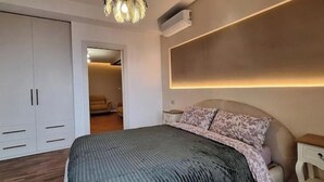 Ein Schlafzimmer mit Bett, Kleiderschrank, Nachttisch und Wandleuchte.