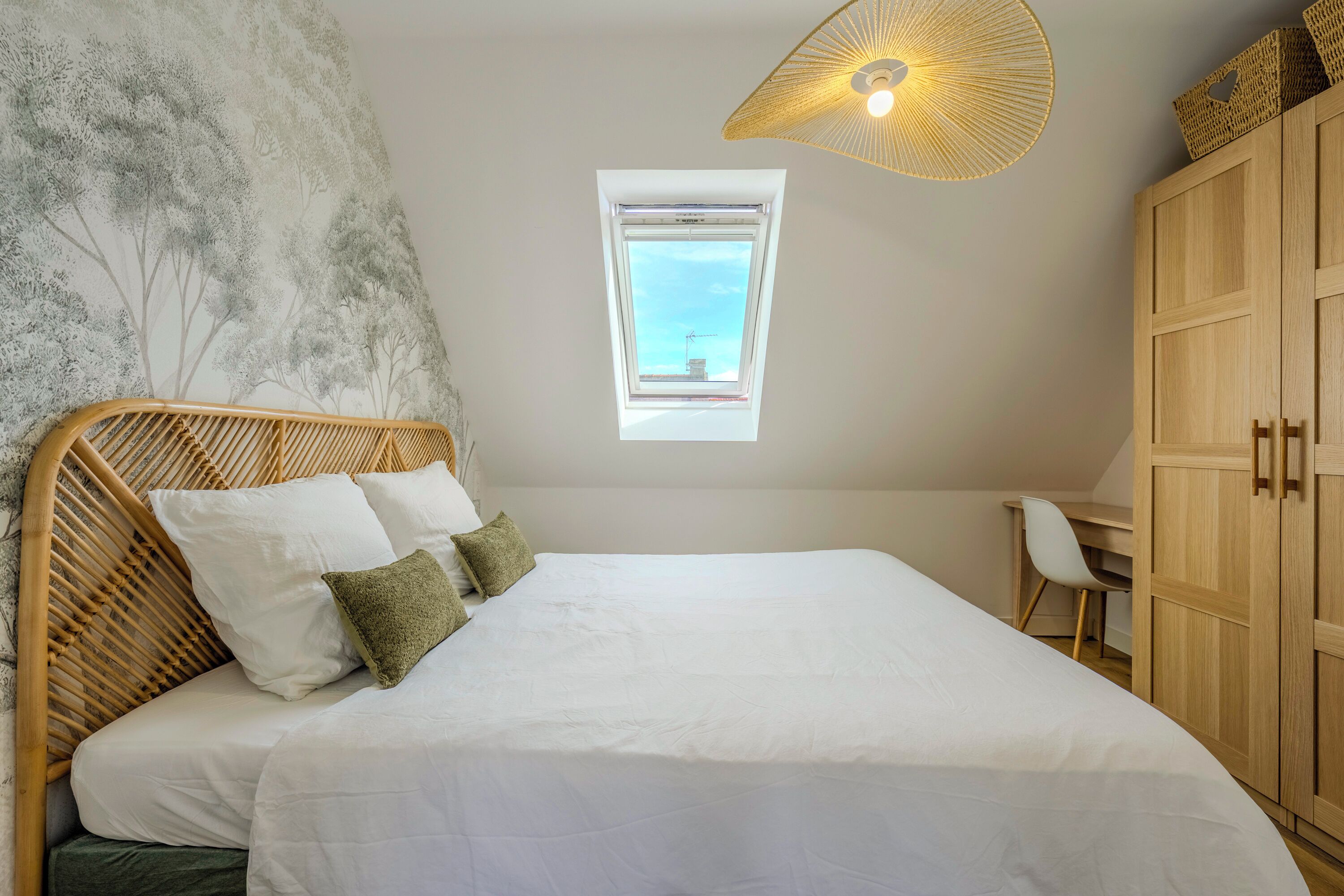 Une chambre à coucher avec un lit, une fenêtre, un bureau et une armoire.