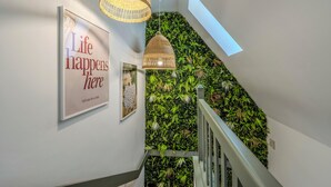 Eine Treppe mit einer grünen Wand und einem gerahmten Schild mit der Aufschrift 'Life happens here'.