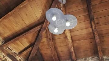 Eine Holzbalkendecke mit freiliegenden Holzbalken und einer dekorativen Leuchte.