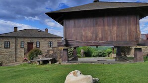 Una construcción rústica de madera con un edificio de piedra al fondo.