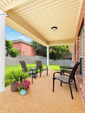 An outdoor patio with a covered area, seating, and potted plants. - The Boardtown, Walk to Campus by Velvet Ditch Villas (Starkville)