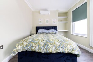 Ein Schlafzimmer mit einem Bett, einem Fenster und Wandbildern.