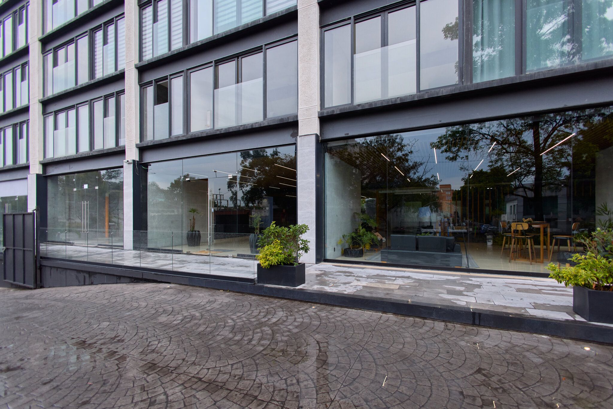 A modern building with large windows and a paved walkway.