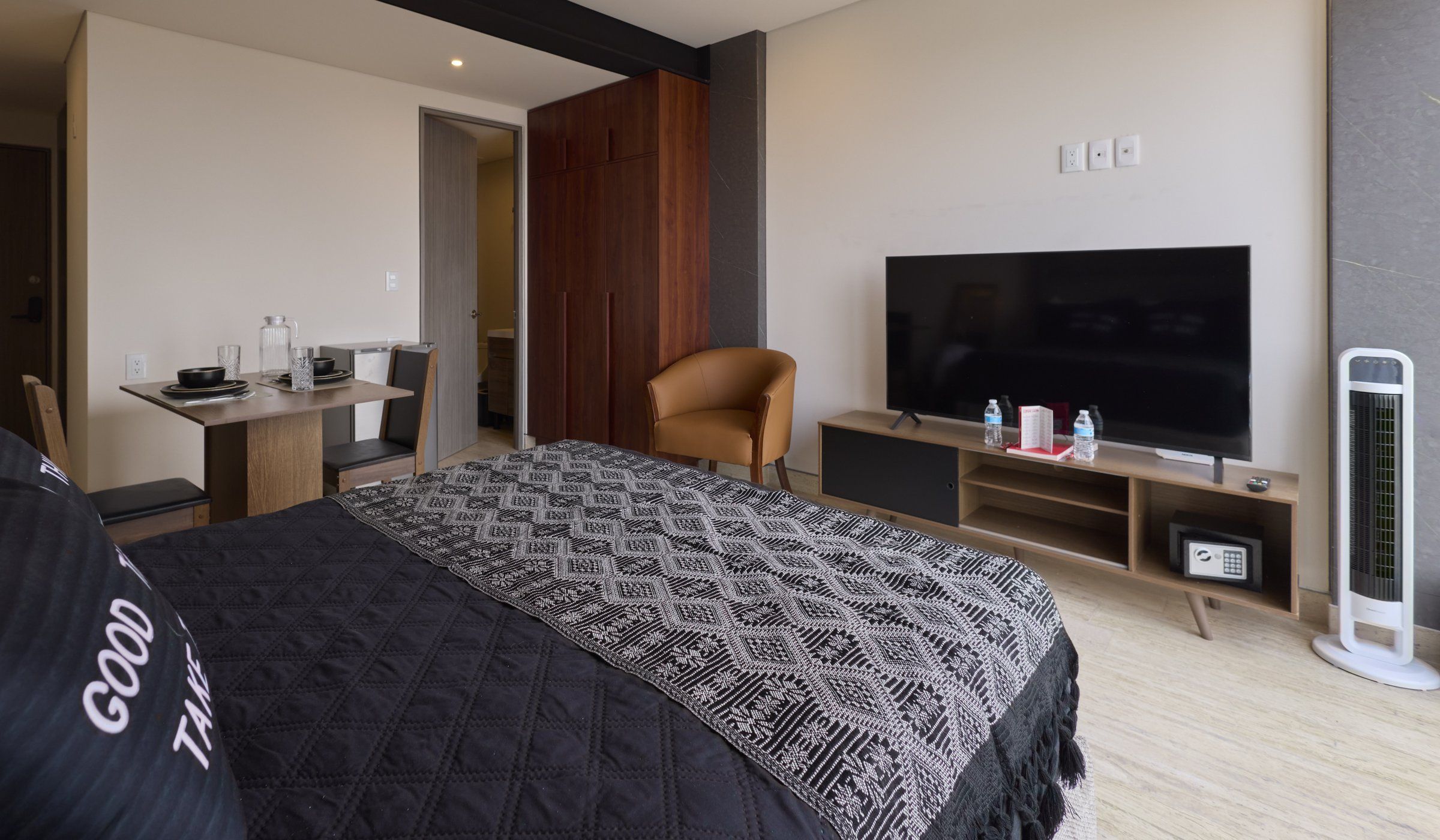 Habitación de hotel con cama, televisión, escritorio, silla y calefactor.