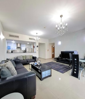 A modern living room with a sofa, coffee table, and a TV.
