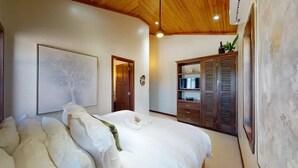 Un dormitorio con una cama grande, un armario y un cuadro en la pared.