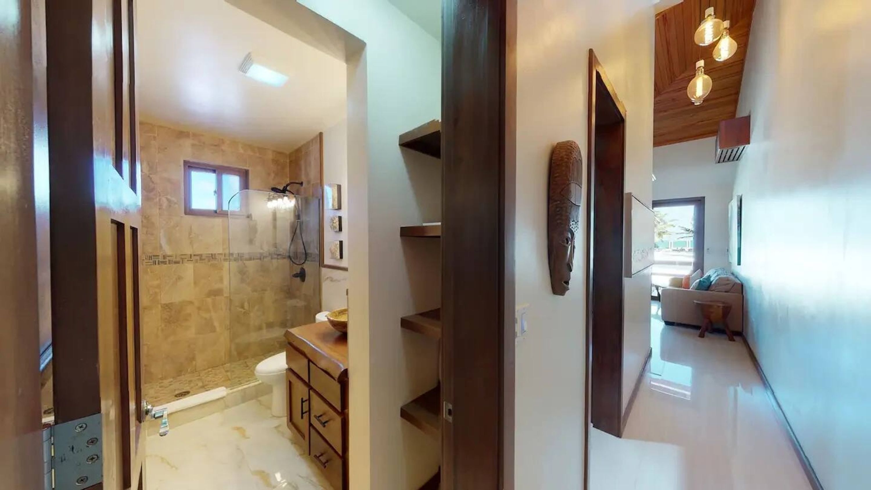 A modern bathroom with a glass-enclosed shower, a wooden vanity, and a marble floor.