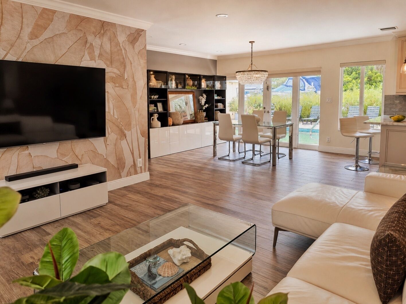 Ein modernes Wohnzimmer mit Flachbildfernseher, Glastisch und einer Couch.