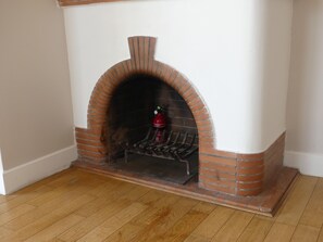 A brick fireplace with a fire extinguisher and a metal grate. - Exceptional apartment with panoramic views, terraces, and private enclosed parking (Grasse)