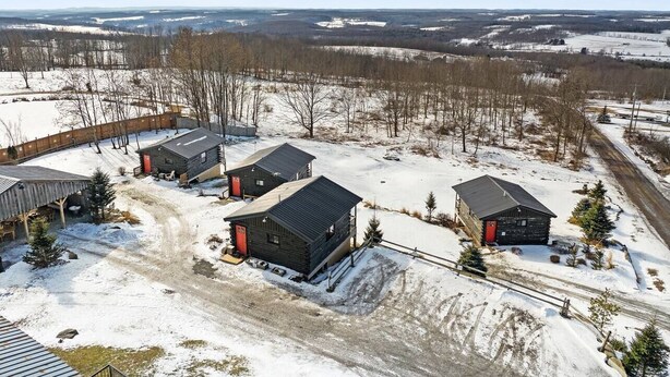 Un paysage enneigé avec plusieurs cabanes et une grange en bois.
