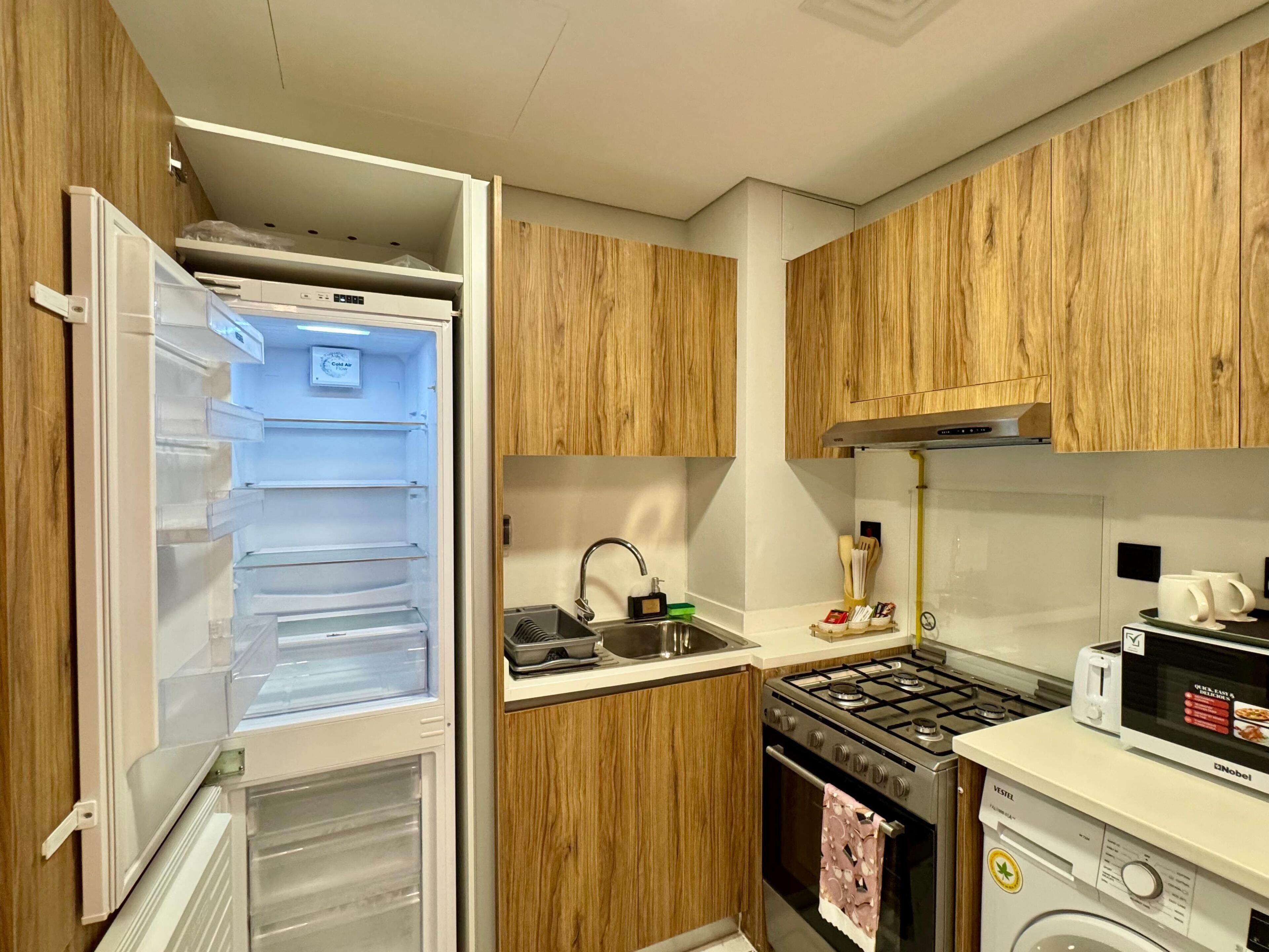 A kitchen with wooden cabinets, a built-in microwave, a gas stove, and a dishwasher.