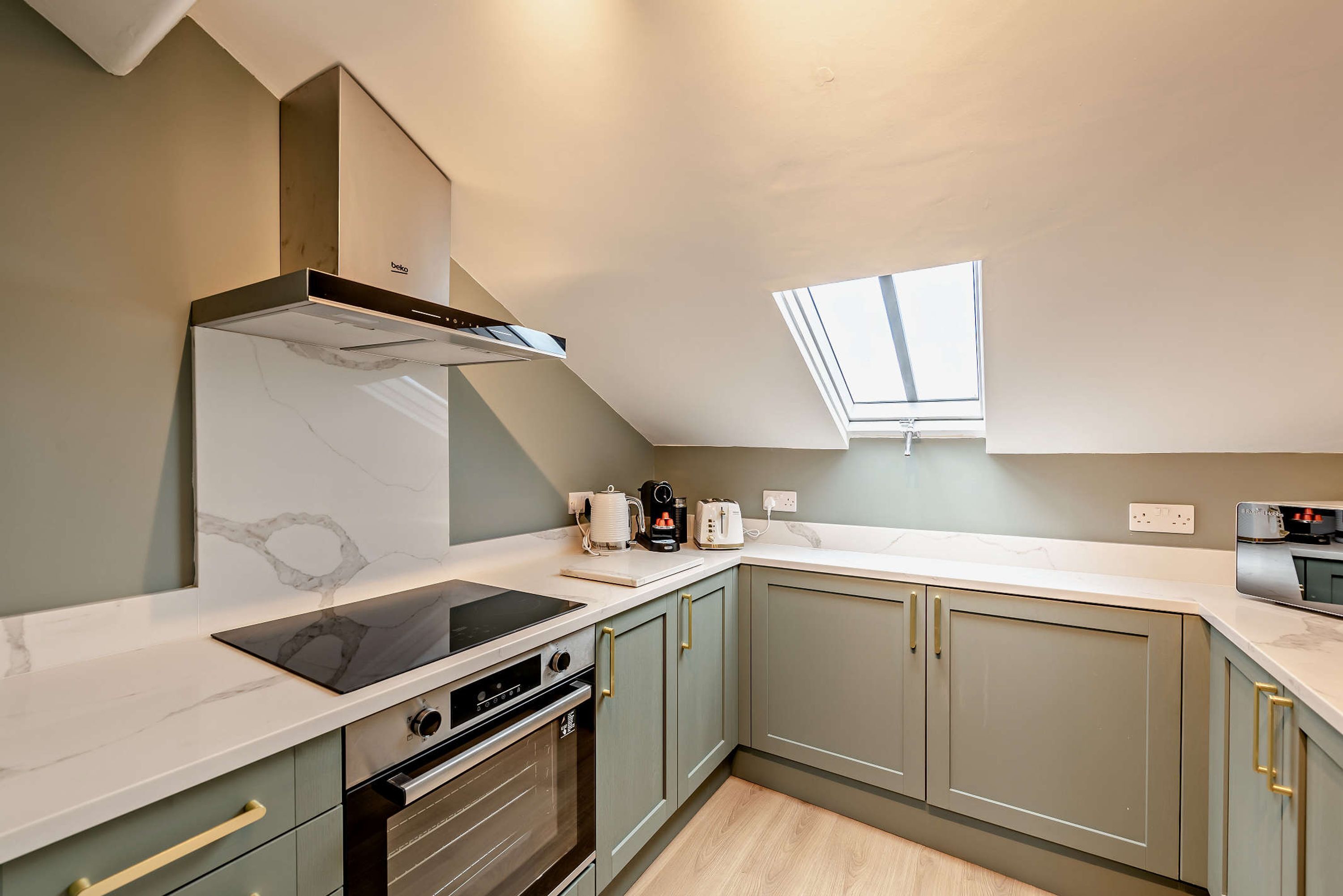 A modern kitchen with a built-in oven, a stovetop, and a range hood.