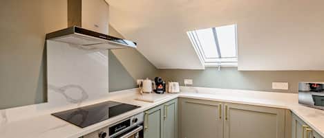 A modern kitchen with a built-in oven, a stovetop, and a range hood.