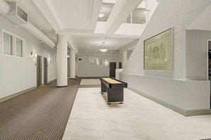 A hotel corridor with a pool table, multiple doors, and a framed artwork on the wall. - New Downtown Indy Group Stay +4BR+Sleeps 14 (Indianapolis)