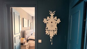 A hallway with a bed, a bedside table, and a wall clock. - Beautiful apartment just a stone's throw from Paris, in a quiet neighborhood (Saint-Cloud)