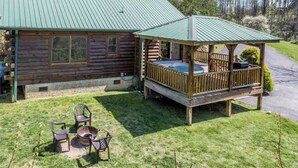 A log cabin with a porch and outdoor seating area. - Lazy Log Cabin at Raccoon Retreat (Whittier)