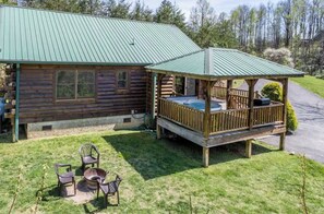 Eine Blockhütte mit Veranda und Außenbereich mit Sitzgelegenheiten.