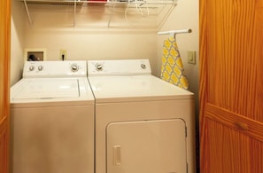 A laundry area with two white washing machines and a drying rack. - Lazy Log Cabin at Raccoon Retreat (Whittier)