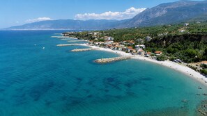 Eine Küstenstadt mit blauem Meer, Sandstrand und Gebäuden entlang der Küste.