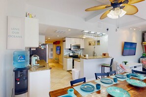 Eine moderne Küche mit Mikrowelle, Backofen und Wasserspender.