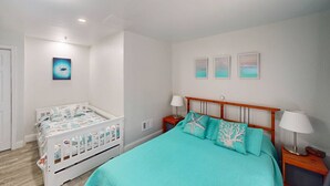 A bedroom with a single bed, a nightstand, a bedside table, and a wall-mounted shelf. - Private Elevator, Spectacular Pool & Marina Views, Steps to Madeira Beach & John's Pass Village (Madeira Beach)