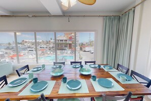 A dining area with a view of a marina and buildings. - Private Elevator, Spectacular Pool & Marina Views, Steps to Madeira Beach & John's Pass Village (Madeira Beach)
