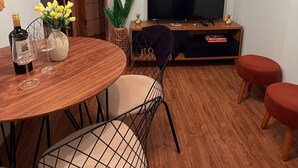 A dining area with a round table, chairs, a television, and a plant. - Country house for relaxation!! 3 bedrooms, swimming pool, fishing lake, fully equipped kitchen. (Cambuí)