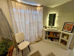 A bathroom with a white sink, a mirror, a framed picture, and a chair. - Country house with a large garden – 10 minutes from the beaches and 5 minutes from O'Fun Park (Avrillé)