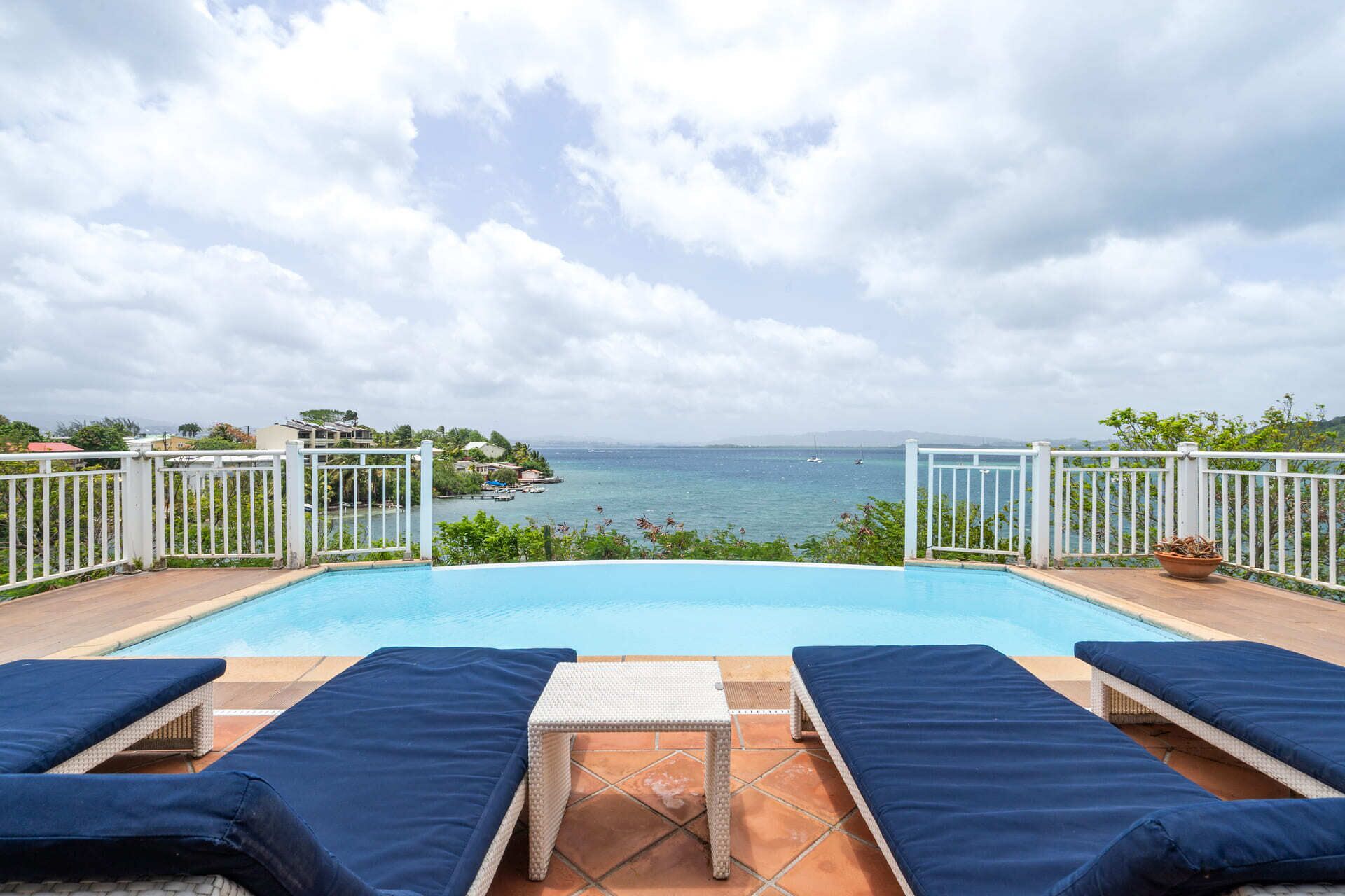 Ein Pool mit Liegestühlen und Meerblick.