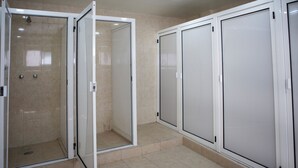 A bathroom with a shower, toilet, and a large mirror. - Casa Local Mestizo Hostal (Mexico City)