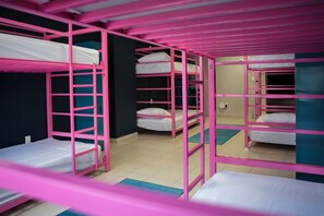 A dormitory room with bunk beds, a blue mat, and a white wall. - Casa Local Mestizo Hostal (Mexico City)