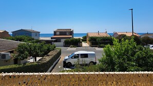 Ein Wohngebiet mit Häusern, einem parkenden Transporter und freiem Blick auf das Meer.