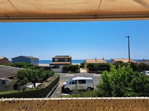 Ein Wohngebiet mit Häusern, einem parkenden Transporter und freiem Blick auf das Meer.