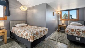 A bedroom with two beds, a chandelier, a window with a view, and a wooden nightstand. - Harvest Ridge Ranch 5 Bedroom Farmhouse Sleeps 14 (Paso Robles)