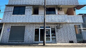 Un edificio de dos pisos con un letrero que indica servicio de hotel las 24 horas.