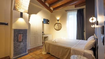 Una habitación de hotel con cama, escritorio, espejo y baño.