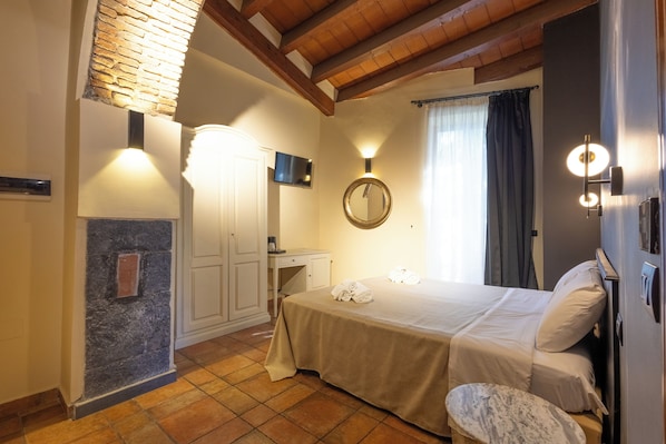 A hotel room with a bed, a desk, a mirror, and a bathroom.